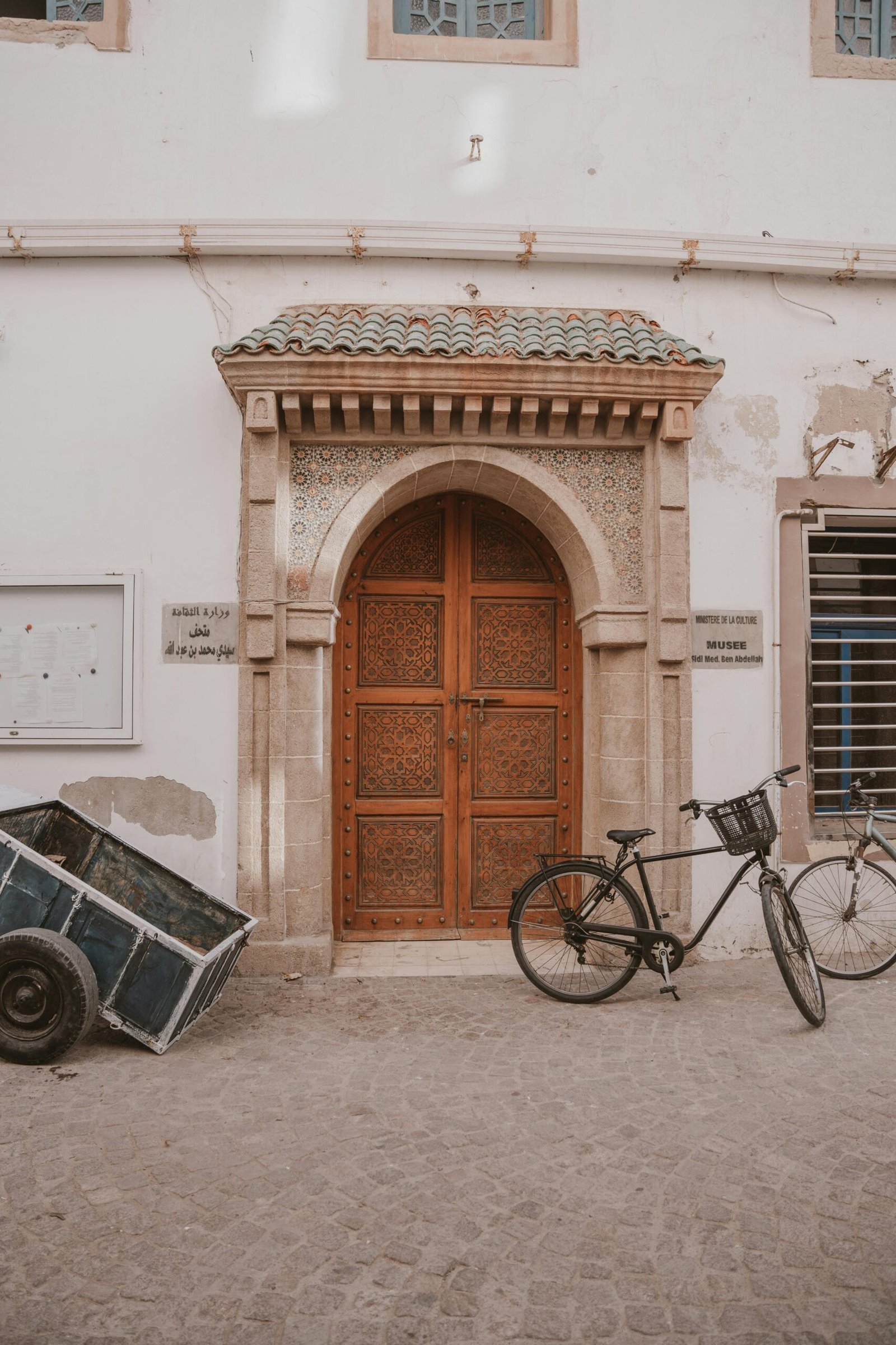 Une porte en bois rustique avec un vélo noir garé à côté dans une ruelle.