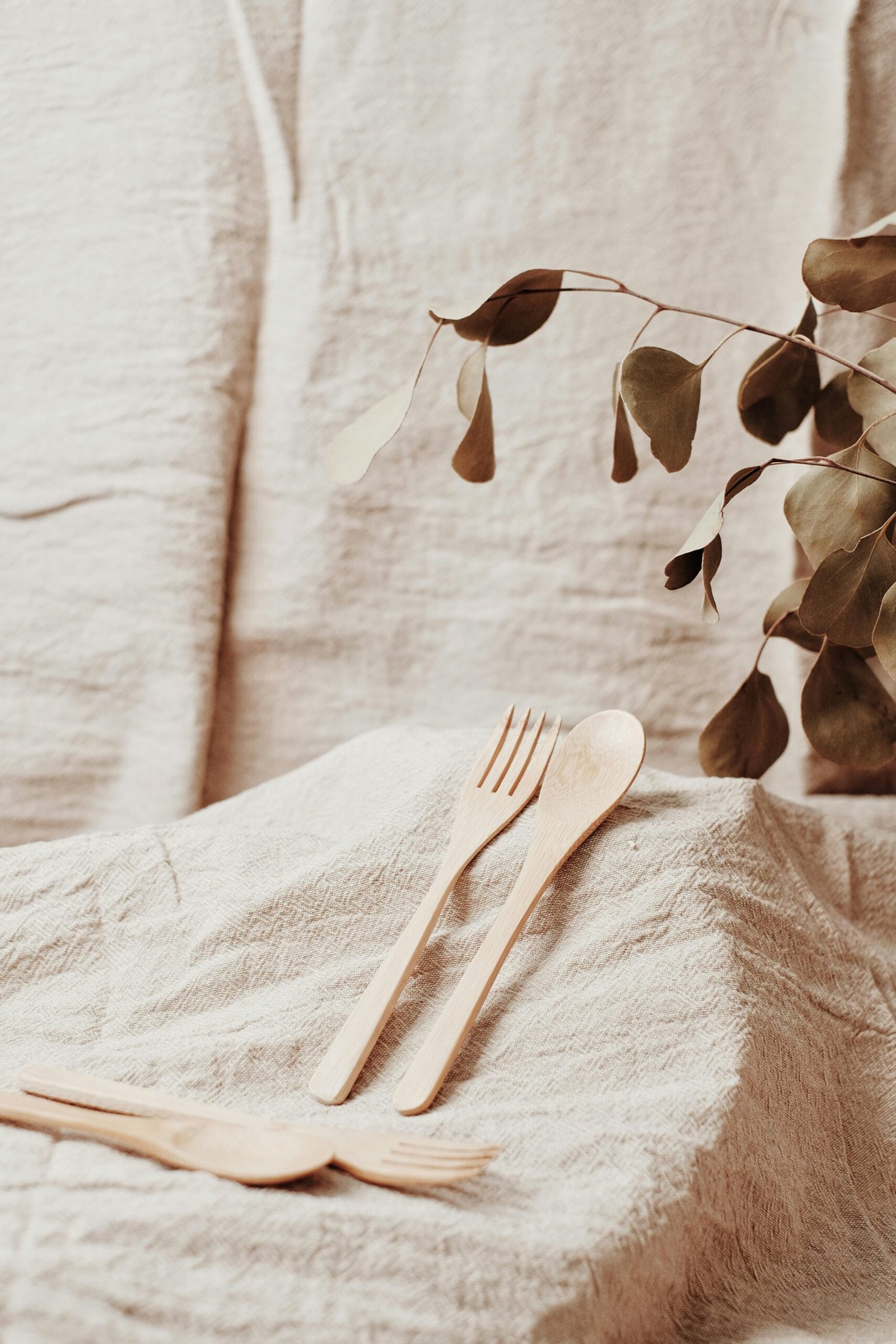 Table dressée avec une nappe en lin beige et des couverts simples